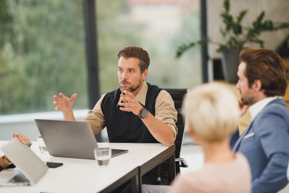 Business professional presenting Salesforce and Jira integration at a laptop in a modern office